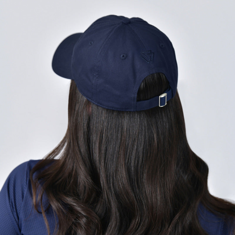 Woman in a Weatherbeeta Performance Cotton Cap Navy, looking slightly to the side.