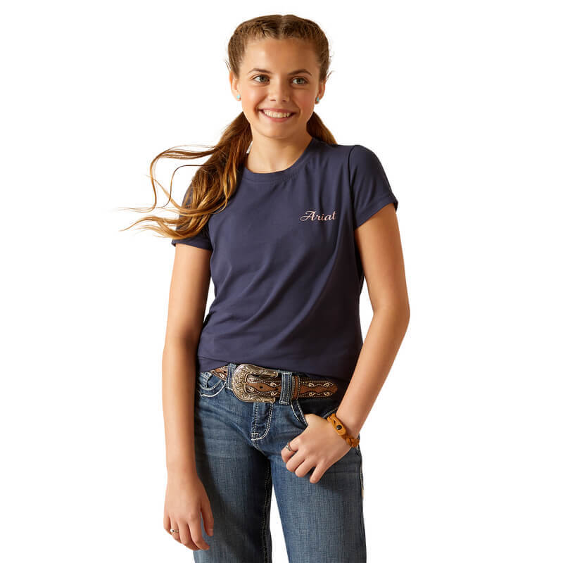 Smiling girl in Ariat Youth Pretty Shield SS Top Navy Eclipse and jeans, hand in pocket.