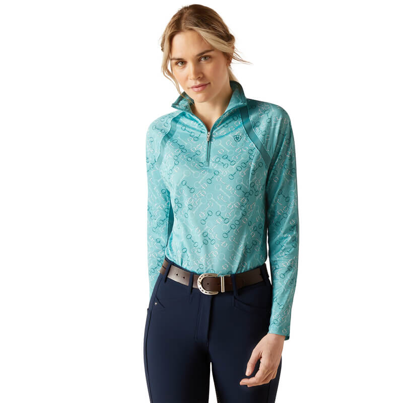 Woman in Ariat Womens Sunstopper 3.0 Baselayer Marine Blue Bit Print, standing and smiling.
