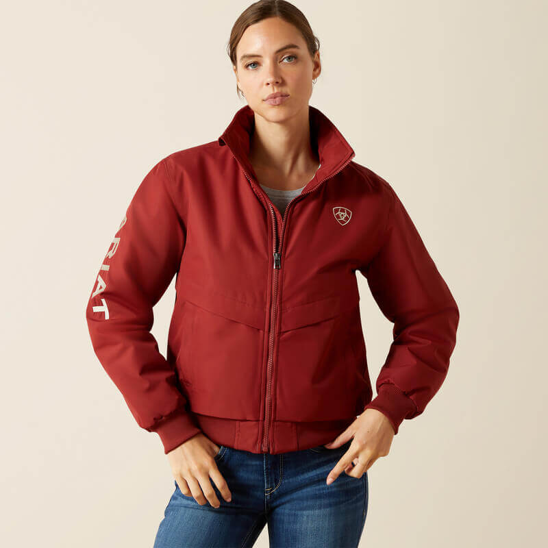 Woman wearing Ariat Womens Stable 2.0 Insulated Jacket in Madder Brown, hands near pockets.