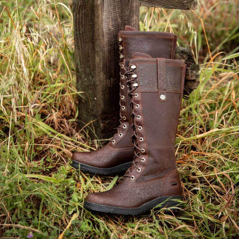 Ariat Womens Wythburn H2O Boots Tobacco Brown lace-up on grass by a wooden post outdoors.