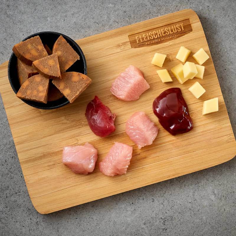 Wooden board with Fleischeslust Meat & Treat Pockets Cheese Sausage 160g on gray.
