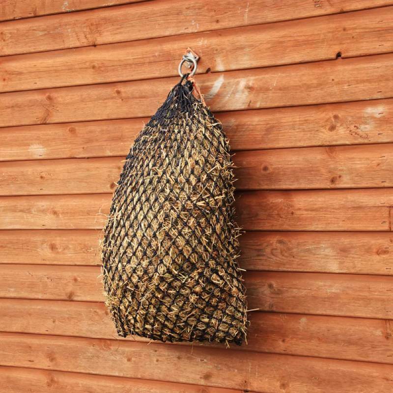 Hy Equestrian Slow Flow Haynet Navy/Pink hangs on a wooden wall.