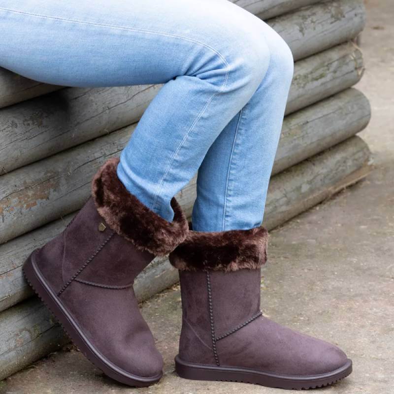 Child wearing Hy Equestrian Hy Chisworth waterproof fleece fur boots in chocolate, sitting outside.