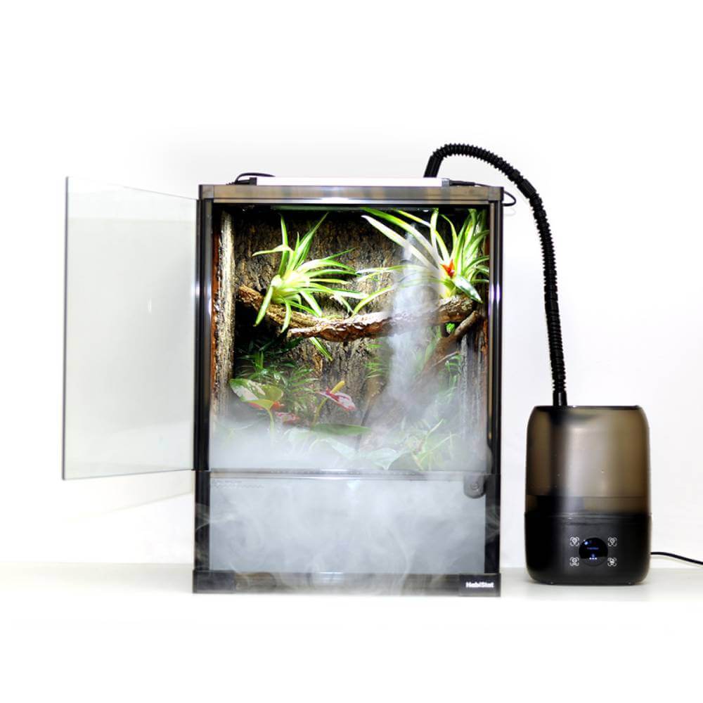 Habistat HabiStat Humidifier releases mist in a glass terrarium with plants.