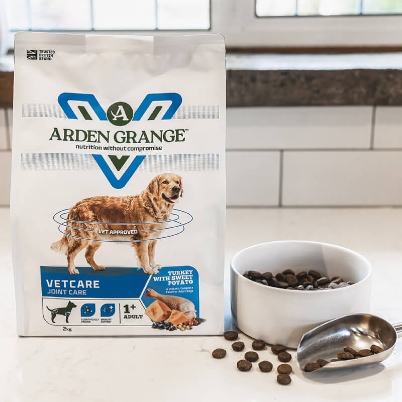 Arden Grange VetCare Joint Care Dog Dry Food with bowl and scoop on kitchen counter.