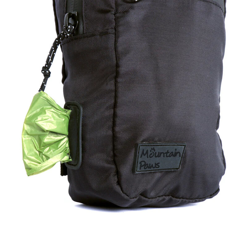 Mountain Paws Dog Snack Pack in black with a green waste bag from the side dispenser slot.