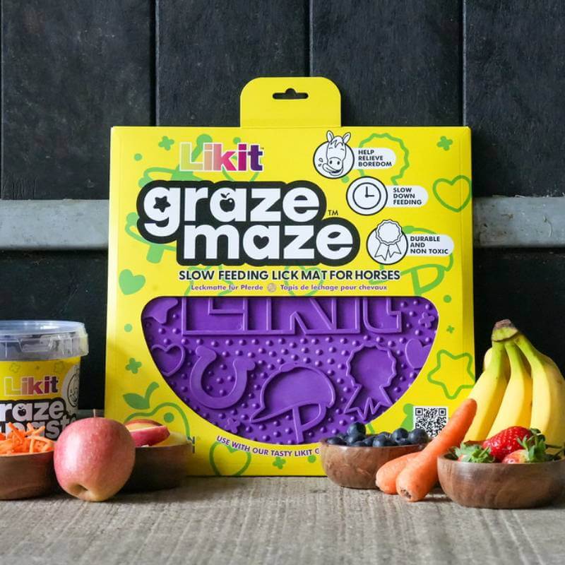 Likit Graze Maze Purple slow feeder for horses in yellow pack, surrounded by fruit and treats.