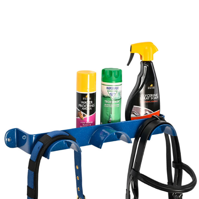 Stubbs Bridle Shelfie Blue holds three cleaning products and black harnesses on a blue rack.