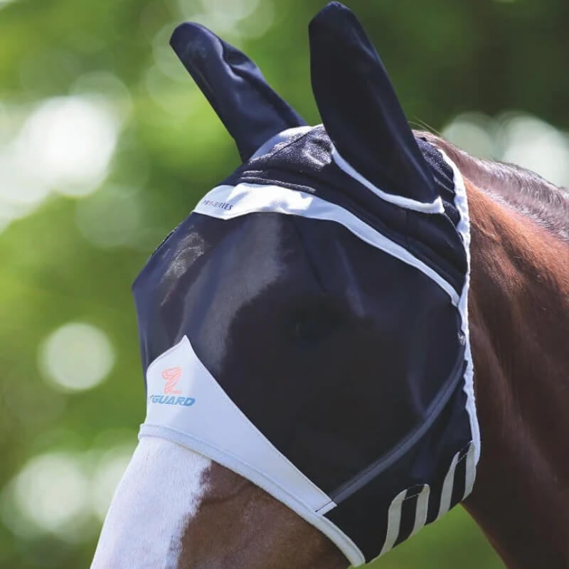 A horse outdoors wears the Shires FlyGuard Pro Fine Mesh Fly Mask with Ears in black.