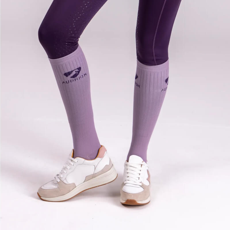 Person wearing purple leggings, Aubrion Winter Performance Socks Adult Mauve, and white sneakers.