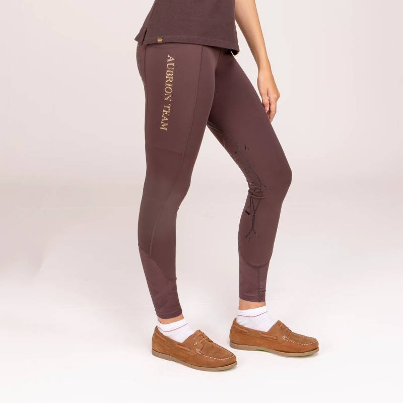 Person in Aubrion Team Riding Tights Umber, white socks, brown shoes, facing left.
