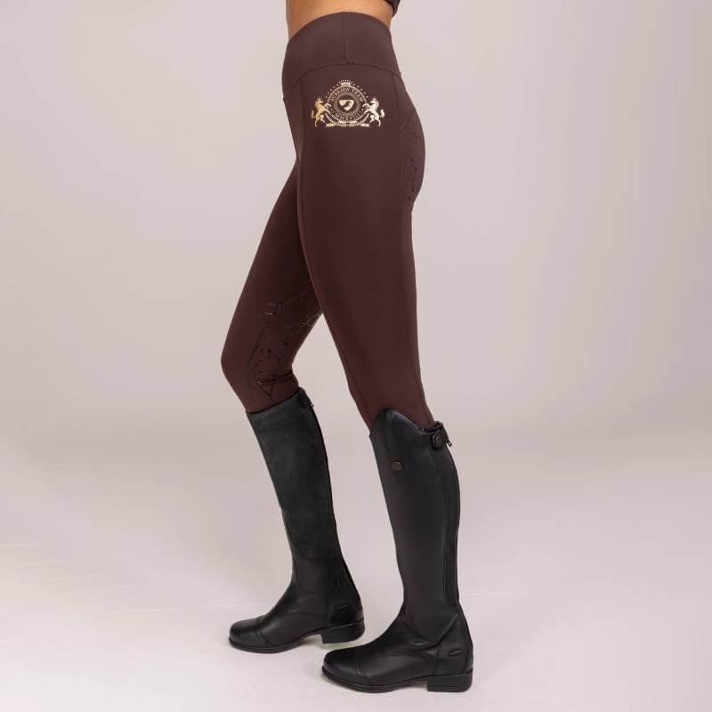 Person wearing Aubrion Team Riding Tights Umber and black knee-high boots.
