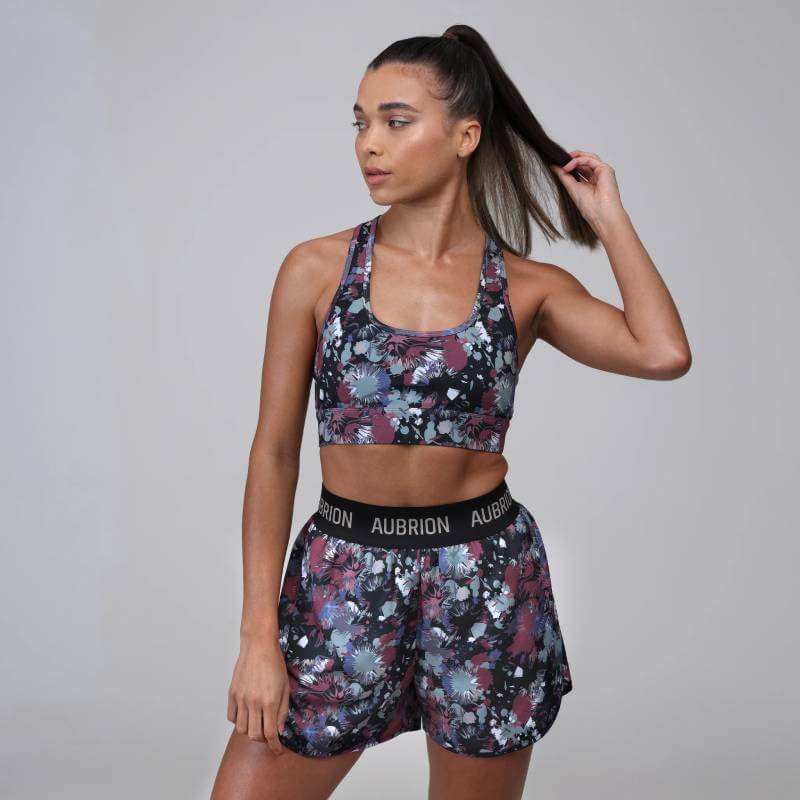 Woman in Aubrion React Power Sports Bra Abstract holding ponytail, looking sideways.