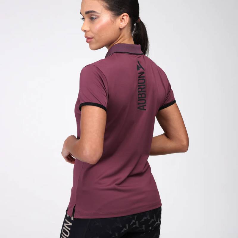 Woman in Aubrion React Tech Polo Mauve and black leggings poses against a white background.
