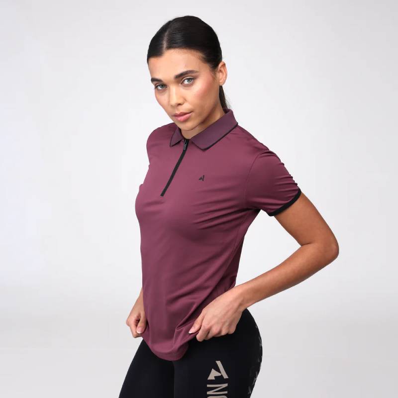 Woman in Aubrion React Tech Polo Mauve and black leggings poses against a white background.