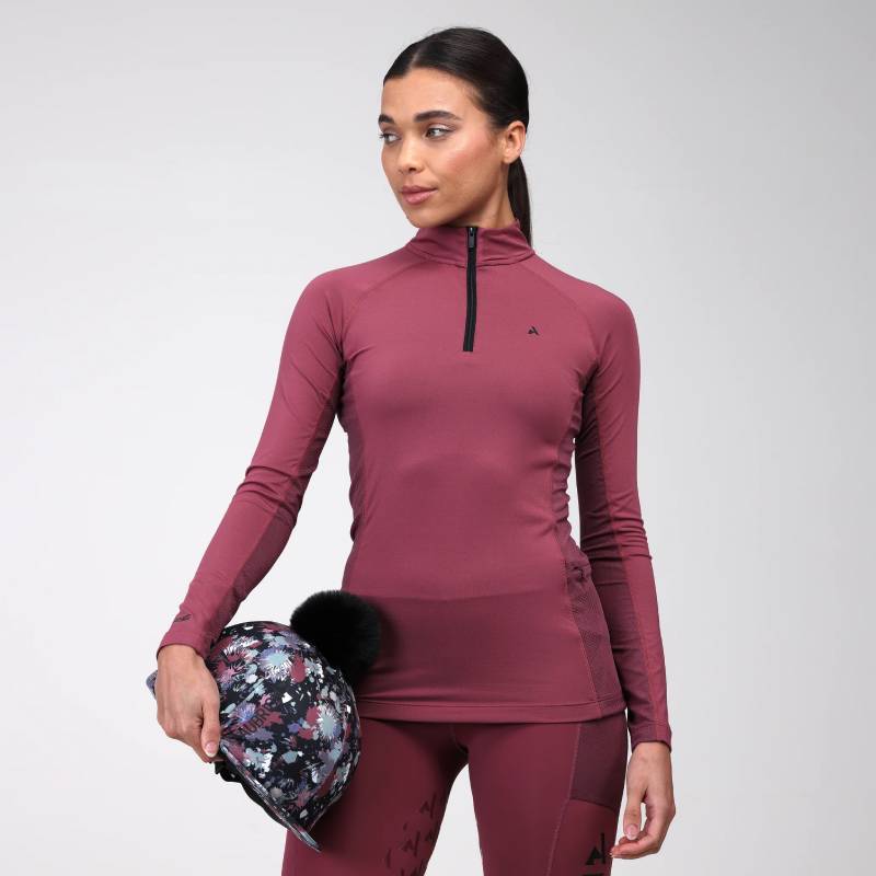 Woman in Aubrion React Long Sleeve Baselayer Mauve holding a floral helmet with black pom-pom.