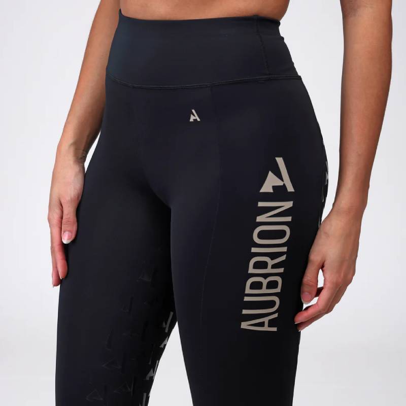 Woman in Aubrion React Rhythm Riding Tights Shadow with left-leg logo and silicone grips.