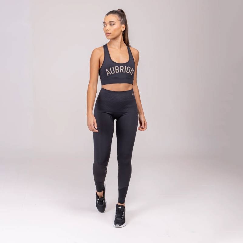 Woman in Aubrion React Sculpt Riding Tights Shadow stands against a light background.