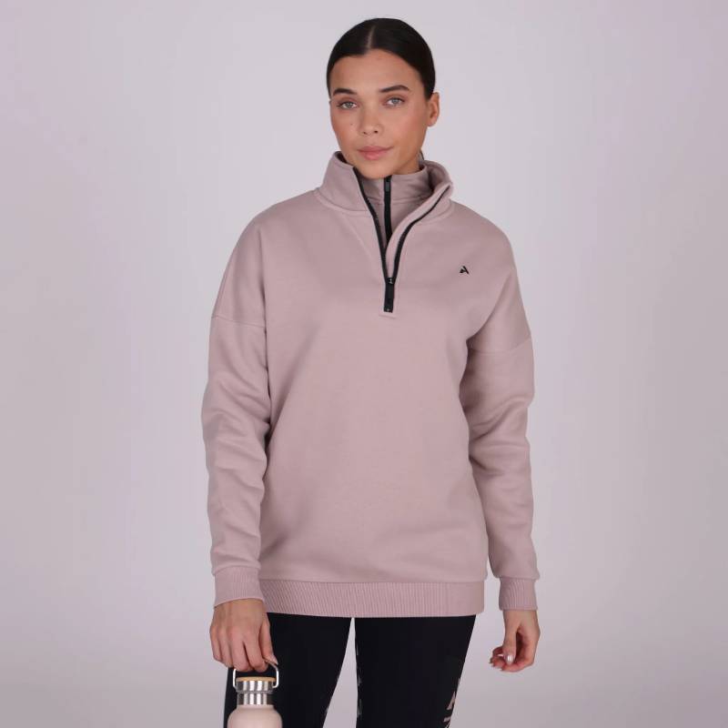 Woman in a Shires Aubrion React Half Zip Sweatshirt Sand holds a water bottle against plain background.
