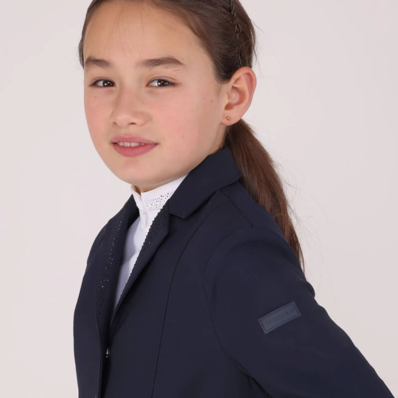 Smiling girl in a Shires Aubrion Optima GX Young Rider Navy Show Jacket and white shirt.