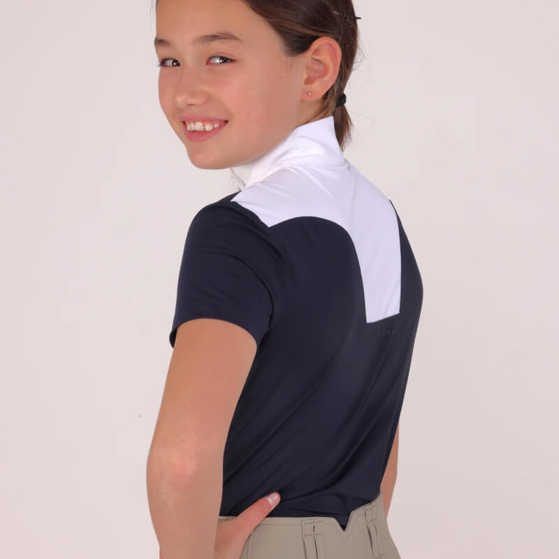Young rider in a Shires Aubrion Optima MX Show Shirt Navy, standing and smiling.