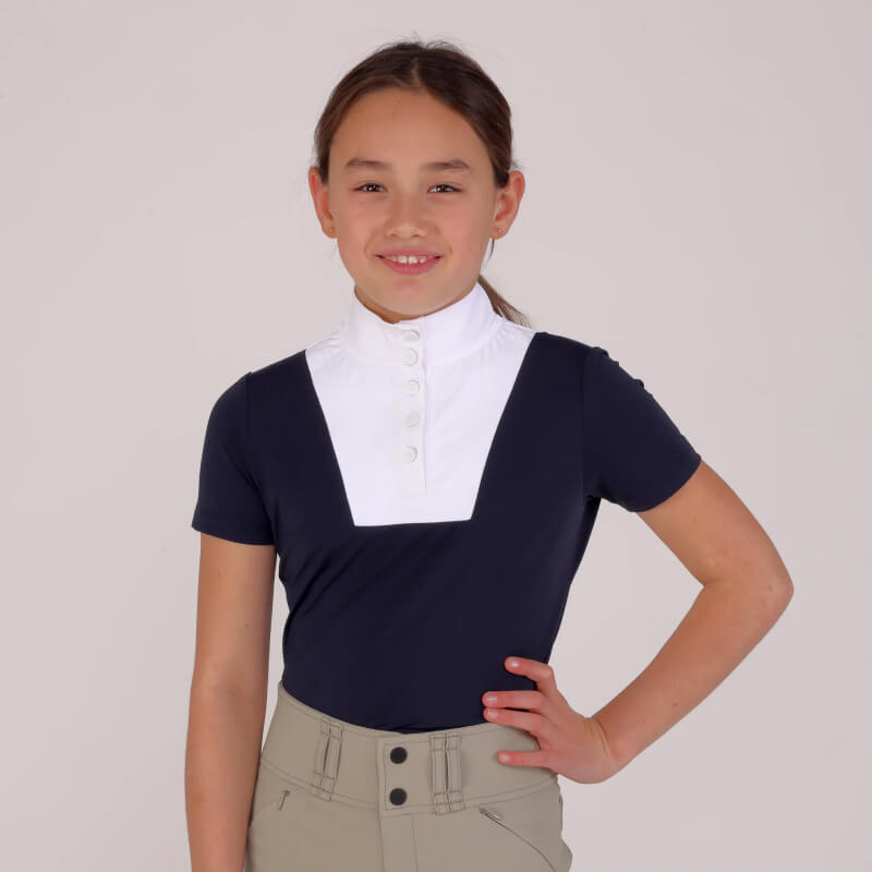 Young rider in a Shires Aubrion Optima MX Show Shirt Navy, standing and smiling.