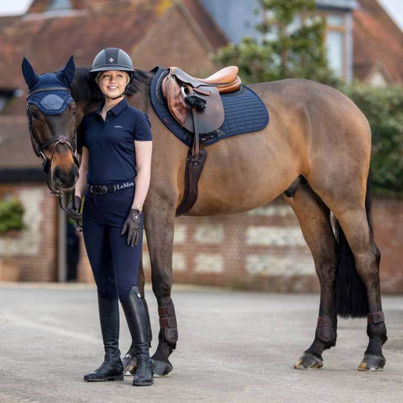 Woman in LeMieux gear with a bay horse wearing the Lemieux Acoustic Pro Fly Hood Navy.