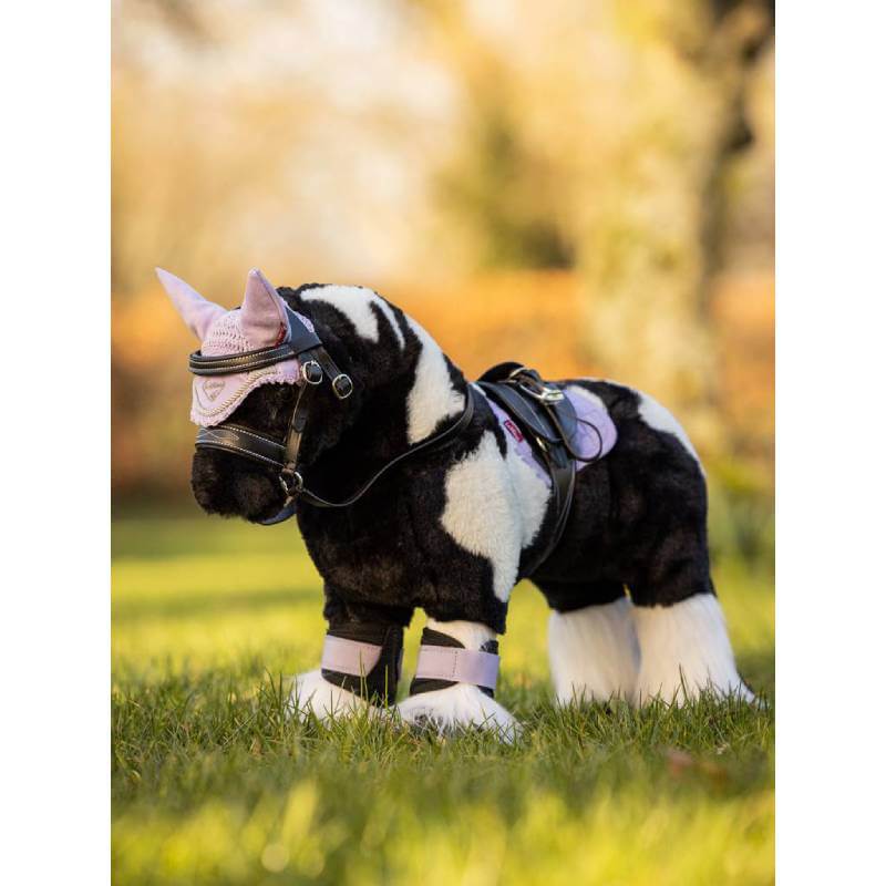 LeMieux Toy Pony Razzle with purple accessories and harness stands on grass.