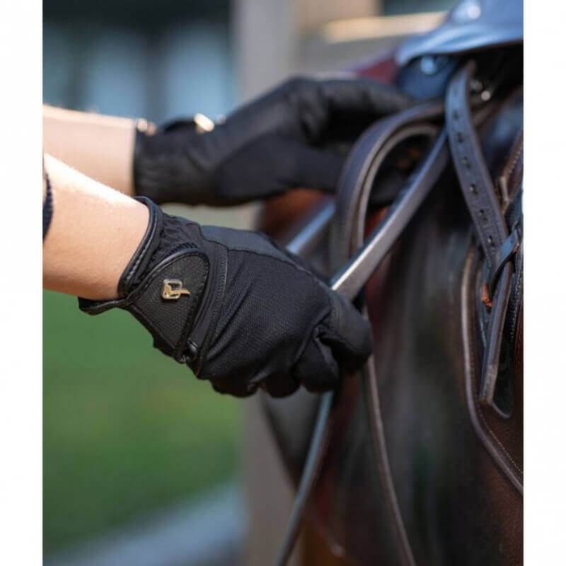 LeMieux Pro Mesh Glove Black adjusting horse tack on a dark leather saddle.
