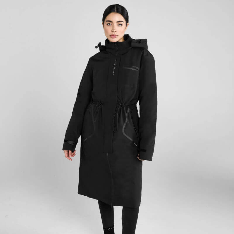 Woman wears Aztec Diamond Black Fleece Lined Rain Jacket against plain gray background.