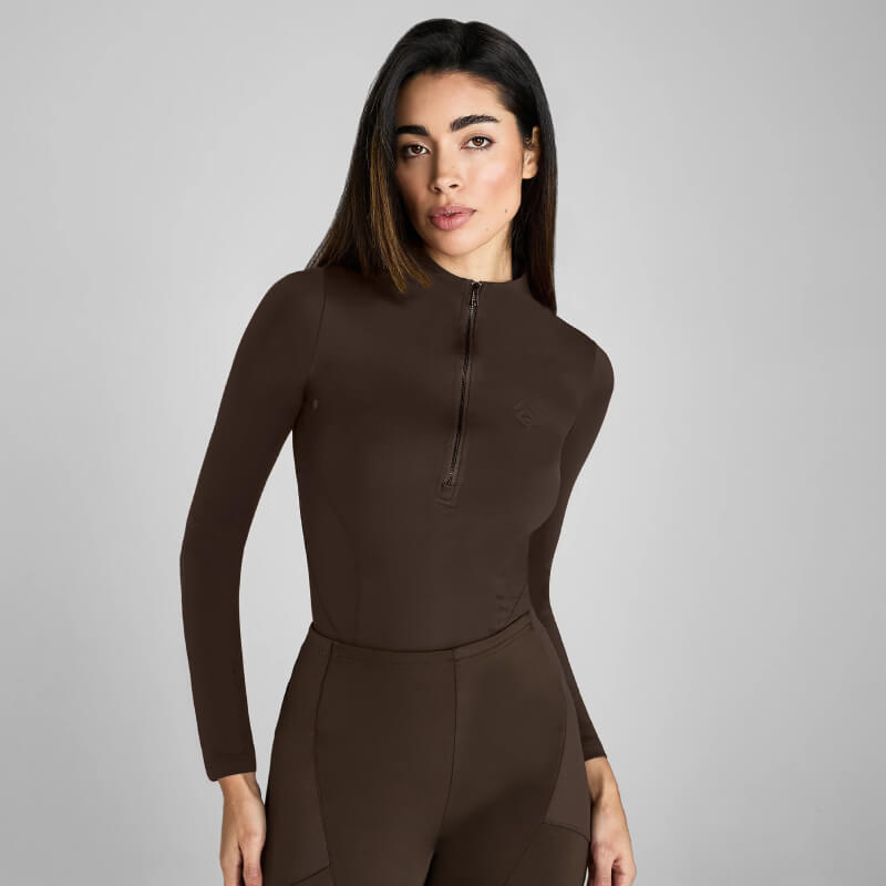 Woman in a fitted Aztec Diamond Core Baselayer Mocha against a plain grey background.