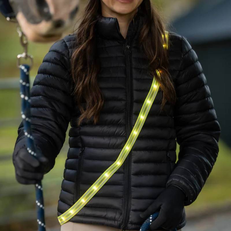 Woman wears Woof Wear LED Sash Hi Vis Yellow—ideal hi-vis riding gear from Woof Wear.