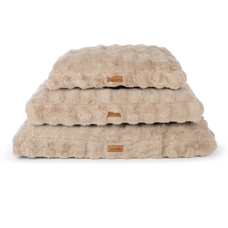 Three stacked Scruffs Alpine Mattress Champagne dog beds with leather tags on the front.