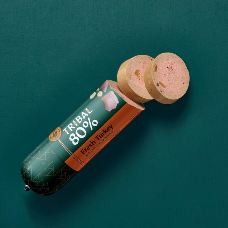 Tribal 80% Dog Sausage 300g, partly sliced, shown on a green background.