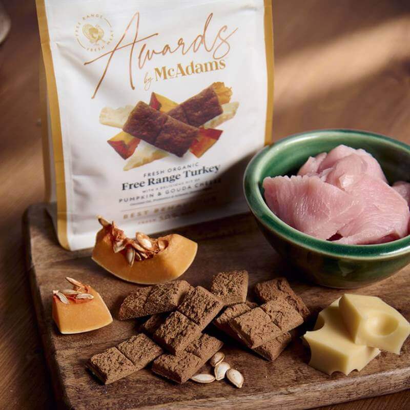 McAdams Semi Moist Dog Treats Turkey with Pumpkin & Cheese 150g on a wooden board with packaging.