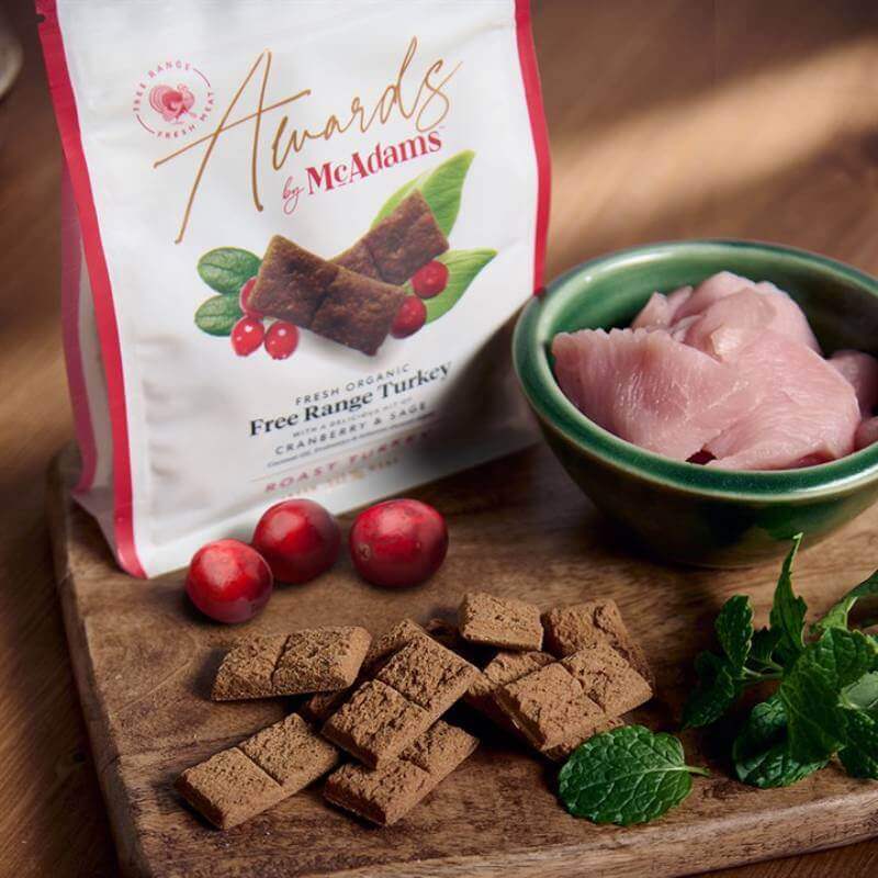 McAdams Semi Moist Dog Treats Roast Dinner Turkey with Cranberry & Sage 150g on a wooden board.