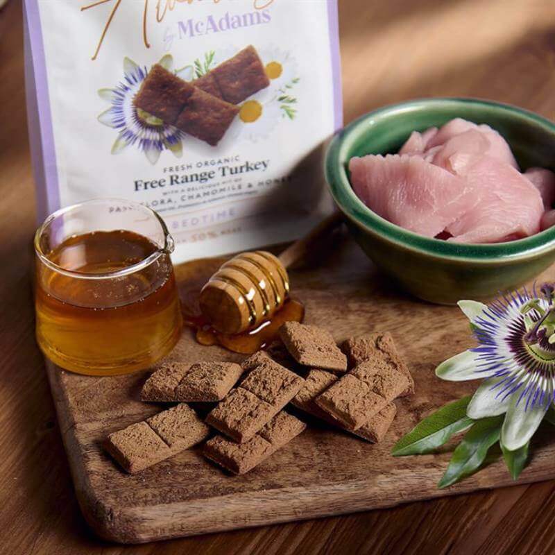 McAdams Restful Sleep Turkey Dog Treats with Passiflora & Honey, shown with honey and a flower.