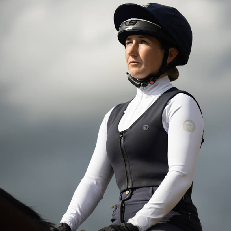 A young rider wears a Racesafe Motion Lite Back Protector Midnight while riding under cloudy skies.