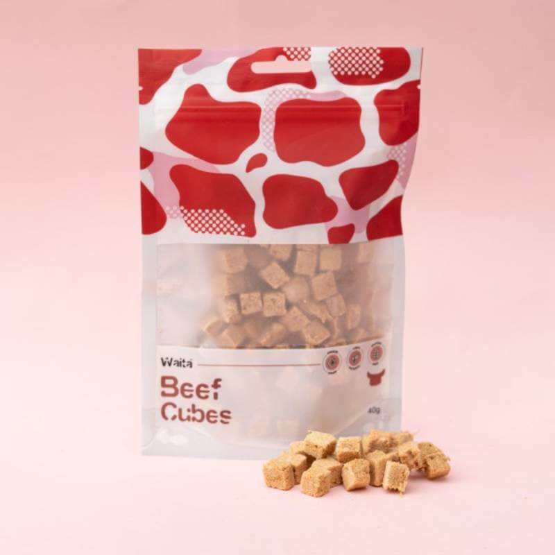 Waita Freeze Dried Beef Cubes Dog &amp; Cat 40g, with treats displayed on a pink background.