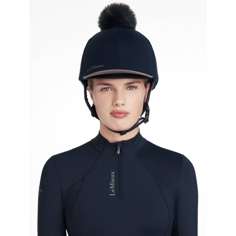Woman in LeMieux Classique Pom Hat Silk Navy with detachable faux fur pom, facing forward.