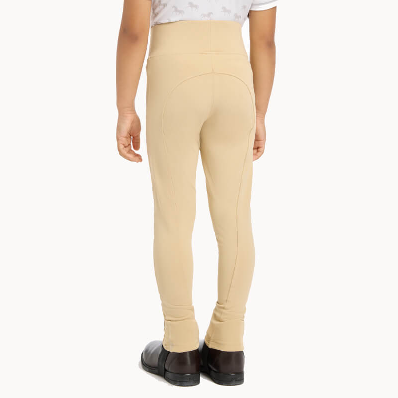 Child in LeMieux Mini Pull On Breech Beige and black boots, made from lightweight technical fabric.