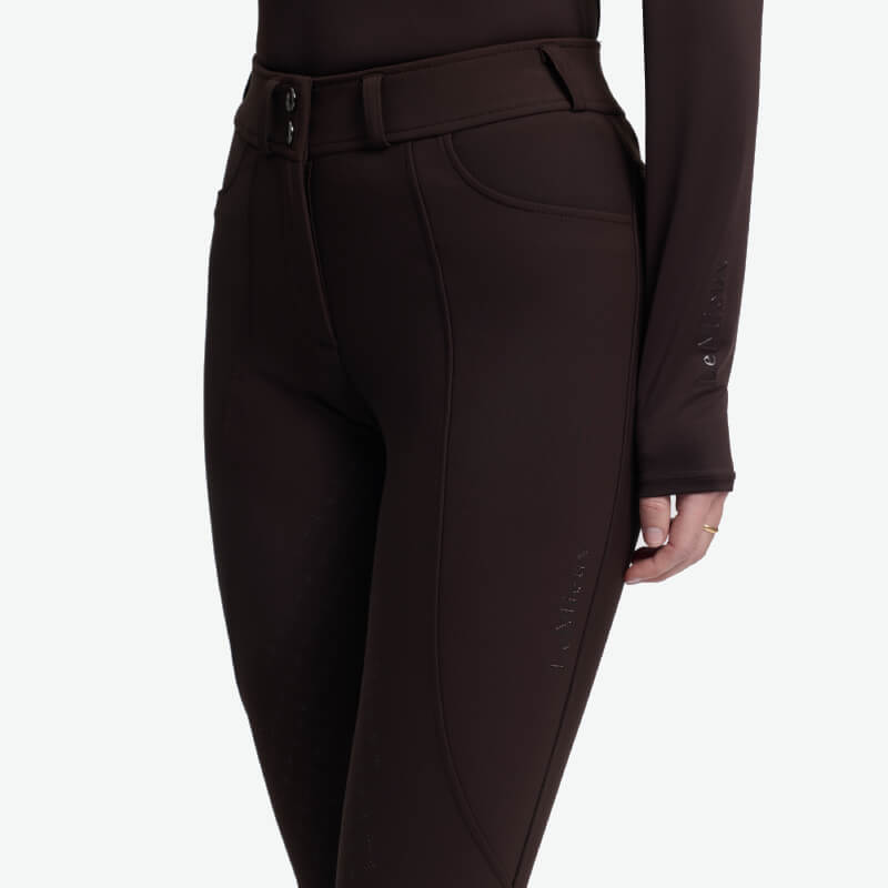 Wearing LeMieux Brilliance Full Seat Breeches Espresso and a matching long-sleeve top.