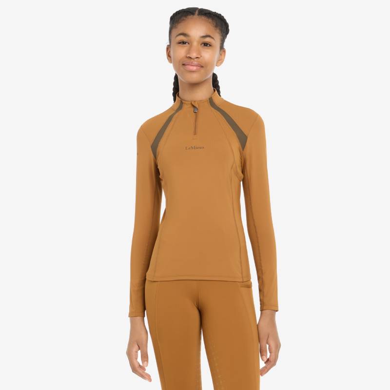 Teen girl in LeMieux Young Rider Mia Mesh Baselayer Ginger, smiling at the camera.