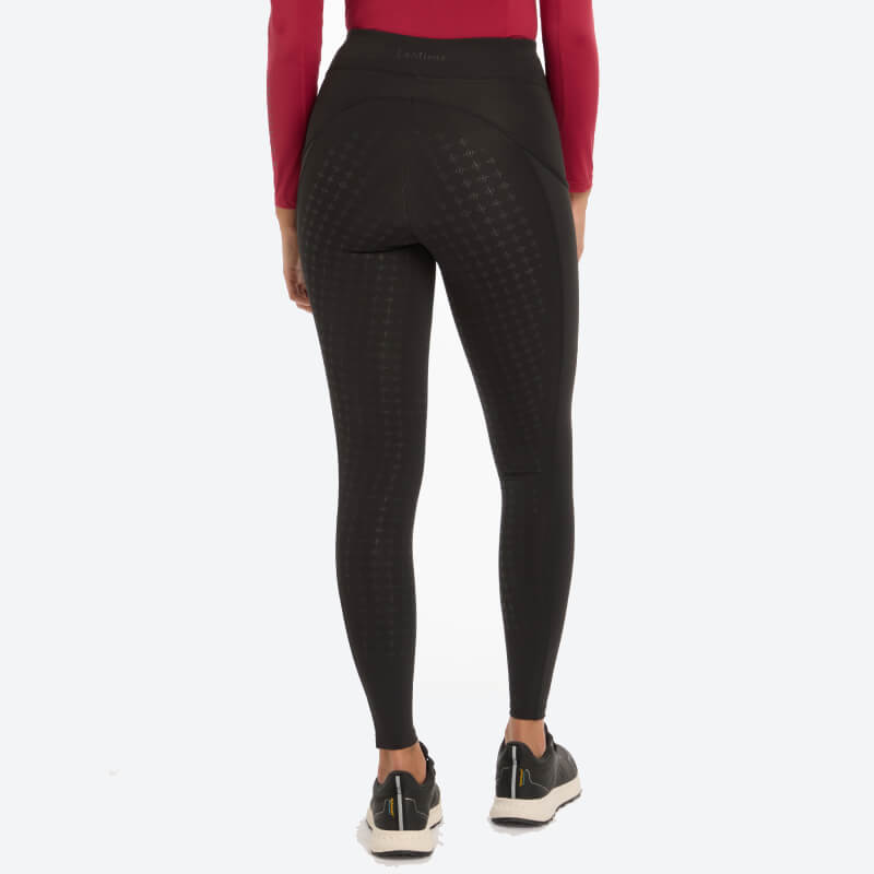 Person in LeMieux Naomi black breeches, red long-sleeve top, and sneakers, shown from the back.