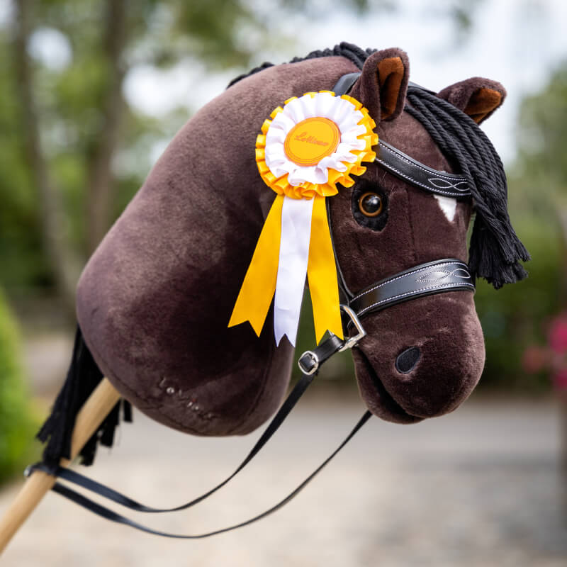 A brown hobby horse with LeMieux Hobby Horse Rosette Pack Multi on its bridle.