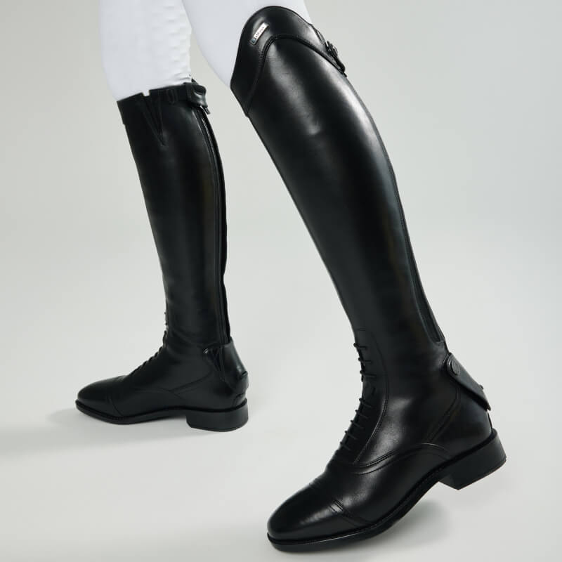 Wearing LeMieux Field Riding Boot Black Short/Full with X-Grip sole and white pants, knees down.