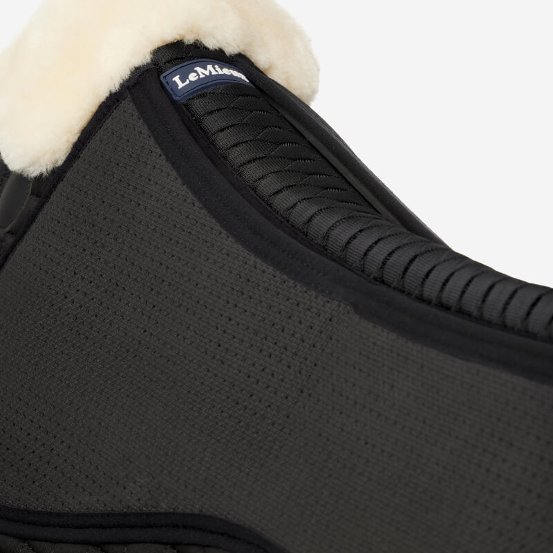 Close-up of LeMieux Streamline Half Pad Black/Natural with fleece trim and shims.