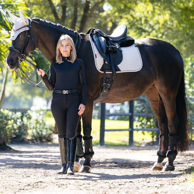 LeMieux Essence Dressage Square Stone pad and black saddle on a brown horse outdoors.