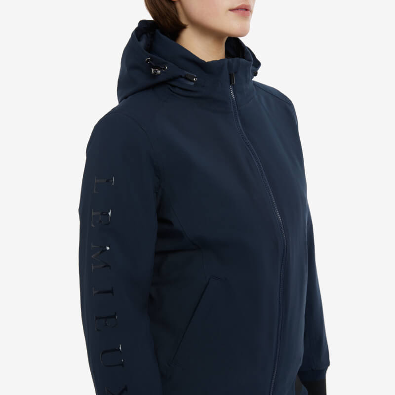 Woman in LeMieux Ladies Team Jacket Navy with sleeve branding, shown in a side view.